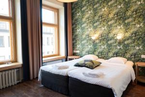 赫尔辛基费恩酒店的卧室配有一张大床,墙上挂有绘画作品