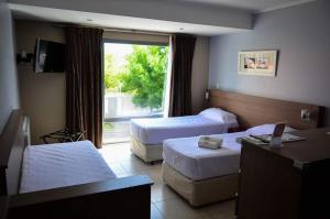 内乌肯Apart Hotel Rivadavia 815的酒店客房设有两张床和窗户。