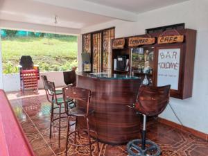 PapagallerosFinca Villa Maju的餐厅内带椅子和柜台的酒吧