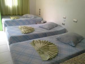 圣若泽杜斯坎普斯Hotel Joabi的带两张床垫的酒店客房内的三张床