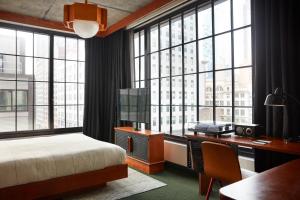 布鲁克林Ace Hotel Brooklyn的卧室配有一张床、一张书桌和窗户。