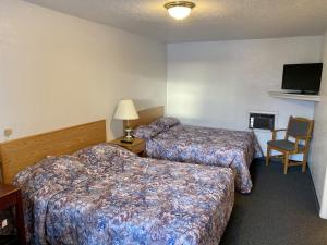 北贝特尔福德Hitching Post Motel的酒店客房,配有两张床和椅子