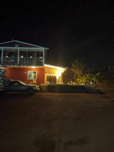瓜达鲁佩镇Villa De Coral的夜晚的房子,前面有一辆汽车