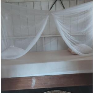 MoreliaHospedaje KOWAPANA BOCAS DE AMACAYACU的客房内的一张带蚊帐的白色床