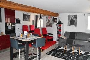 Villeneuve-sous-DammartinCINEMA Appartement 10mn Aeroport Roissy CDG的客厅配有桌子和红色椅子