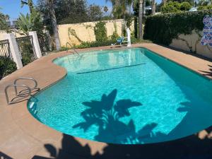 安纳海姆Legacy inn & suites的蓝色的游泳池,里面种有棕榈树