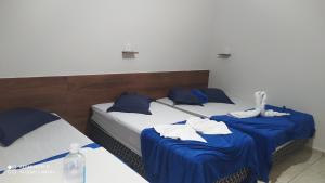 阿帕雷西达Pousada Quarto com frigobar,ar e garagem gratuita的蓝色和白色的客房内的两张床