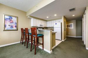 代托纳海滩Unit 2427 Ocean Walk - 2 Bedroom Ocean Front的厨房配有两把椅子和带冰箱的台面