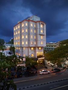 特里凡得琅Ariya Nivaas A Vegetarian Hotel的一座大型白色建筑,在城市街道上设有窗户
