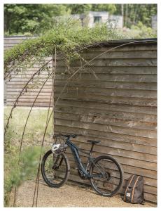 沃勒维克Volvic Organic Resort的停放在木结构建筑旁边的自行车