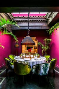 非斯Riad Fes - Relais & Châteaux的一间带桌子和绿色椅子的用餐室