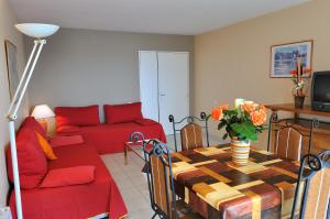戛纳渣油维拉毛帕森酒店的客厅配有红色的沙发和桌子