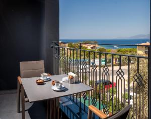 库萨达斯TNR Otel & Spa的阳台配有桌子,享有海景。