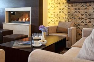 圣季米特里奥斯Theta Hotel的客厅配有桌椅和壁炉