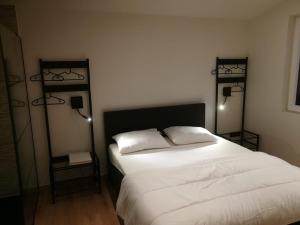 利赫塔特Hogenberg Heiken Lichtaart / Kasterlee的一间卧室配有一张带两盏灯的大型白色床。