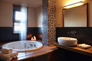 圣季米特里奥斯Theta Hotel Pelion的一间带浴缸和大镜子的浴室