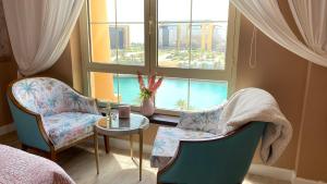 阿卜杜勒国王经济城B-LBAIT KAEC Honeymoon Style for family的一间卧室配有两把椅子、一张桌子和一个窗户。