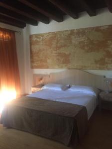 戈里齐亚Casa vacanze Girardi的卧室配有一张床,墙上挂有绘画作品