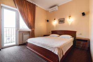 敖德萨叶卡捷琳娜二世酒店的一间卧室设有一张床和一个大窗户