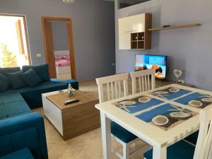 都拉斯Guest House Tian & Hojz的客厅配有桌子和蓝色沙发