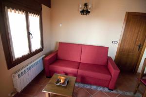 ValbonaApartamentos Turisticos Sanahuja的客厅里一张红色的沙发,配有桌子