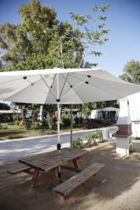 贝纳哈拉菲尼扎普拉亚野营山谷酒店的一张带白色雨伞的木制野餐桌