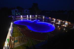 达文盖雷DVG Socials Retreat的夜间大型蓝色游泳池,灯光照亮