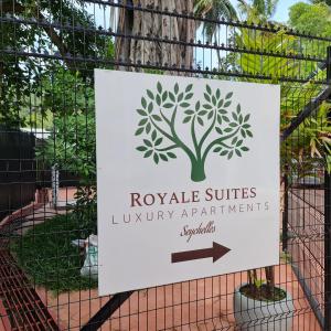 安塞罗亚莱Royale Suites by Arc Royal Luxury Apts的门上的一个标志,上面有树