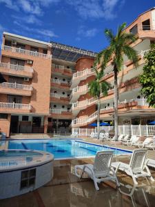 梅尔加Zahira Hotel Melgar的一座带椅子的游泳池和一座建筑的酒店