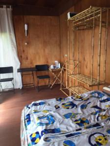 贝都古jungleadventure cabin camping的卧室配有1张床、1张桌子和1把椅子