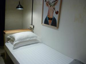 马六甲Ola Hostel的卧室配有一张床铺,墙上挂着鹿的照片