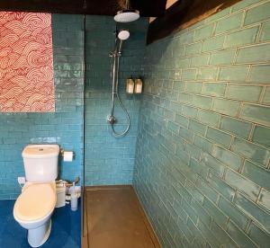 费克纳姆Sculthorpe Mill的一间带卫生间和绿色砖墙的浴室