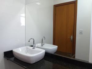 南圣克鲁斯Flat Santa Cruz do Sul的浴室设有2个白色水槽和镜子