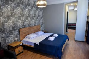 茨卡尔图博Tskaltubo Epic Hotel & Spa的一间卧室配有一张带蓝色毯子的大床