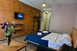 茨卡尔图博Tskaltubo Epic Hotel & Spa的一间卧室设有一张床和砖墙