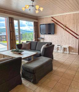 特吕西尔In the middle of Trysil fjellet - Welcome Center - Apartment with 4 bedrooms and sauna - By bike arena and ski lift的客厅配有沙发和桌子