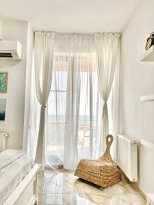 马马亚Studio Crazy Beach Summerland的卧室设有大窗户和白色窗帘