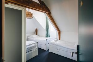 雷恩Les Chouettes Hostel的小房间设有两张床和镜子