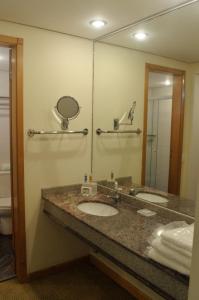 巴鲁埃里Sol Alphaville Hotel & Residence的一间带两个盥洗盆和大镜子的浴室
