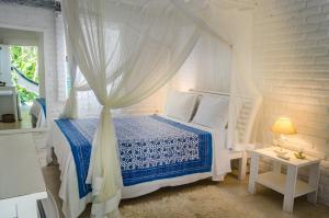 托兰克索Pousada Capim Santo的一间卧室配有一张带天蓬的床