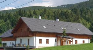 KrásnáPenzion Stříbrník的黑色屋顶的大型白色谷仓
