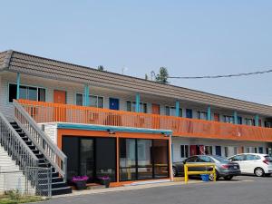斯波坎Howard Johnson by Wyndham Spokane的一座橙色的建筑,汽车停在停车场