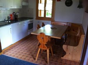 Eriz埃里卡小屋公寓的厨房配有木桌和木椅