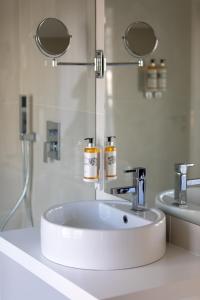 科英布拉Hotel Mondego的浴室设有白色水槽和两面镜子