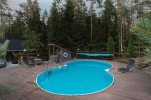 埃斯波Sirpa's Artistic Nuuksio Retreat with Heated Pool的一个带椅子和桌子的甲板上的游泳池