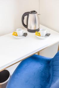 科英布拉Hotel Mondego的茶壶和柜台上的两个杯子