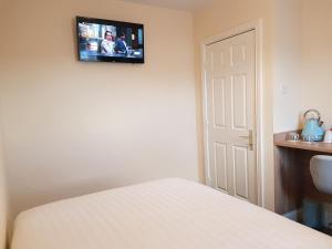 都柏林Bella Room with free minibar tea&coffee的卧室配有一张床,墙上配有电视。