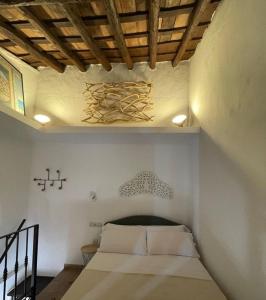 EsteponaCasita Beatriz - by Casa del Patio的一间卧室配有白色床单和木制天花板。