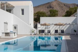 佩里萨Petra Aqua Villa的一座游泳池,其底楼是白色的房屋和山脉