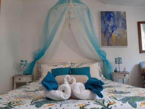 杜布罗夫尼克Atelier Tina Art Home的床上有两只填充的动物,床上有蓝色枕头